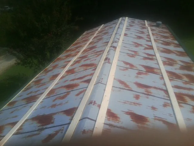 Rusted metal roof panels with new wood purlins before replacement — Storm Damage Roof Repair in Elbridge by Roofing Brothers