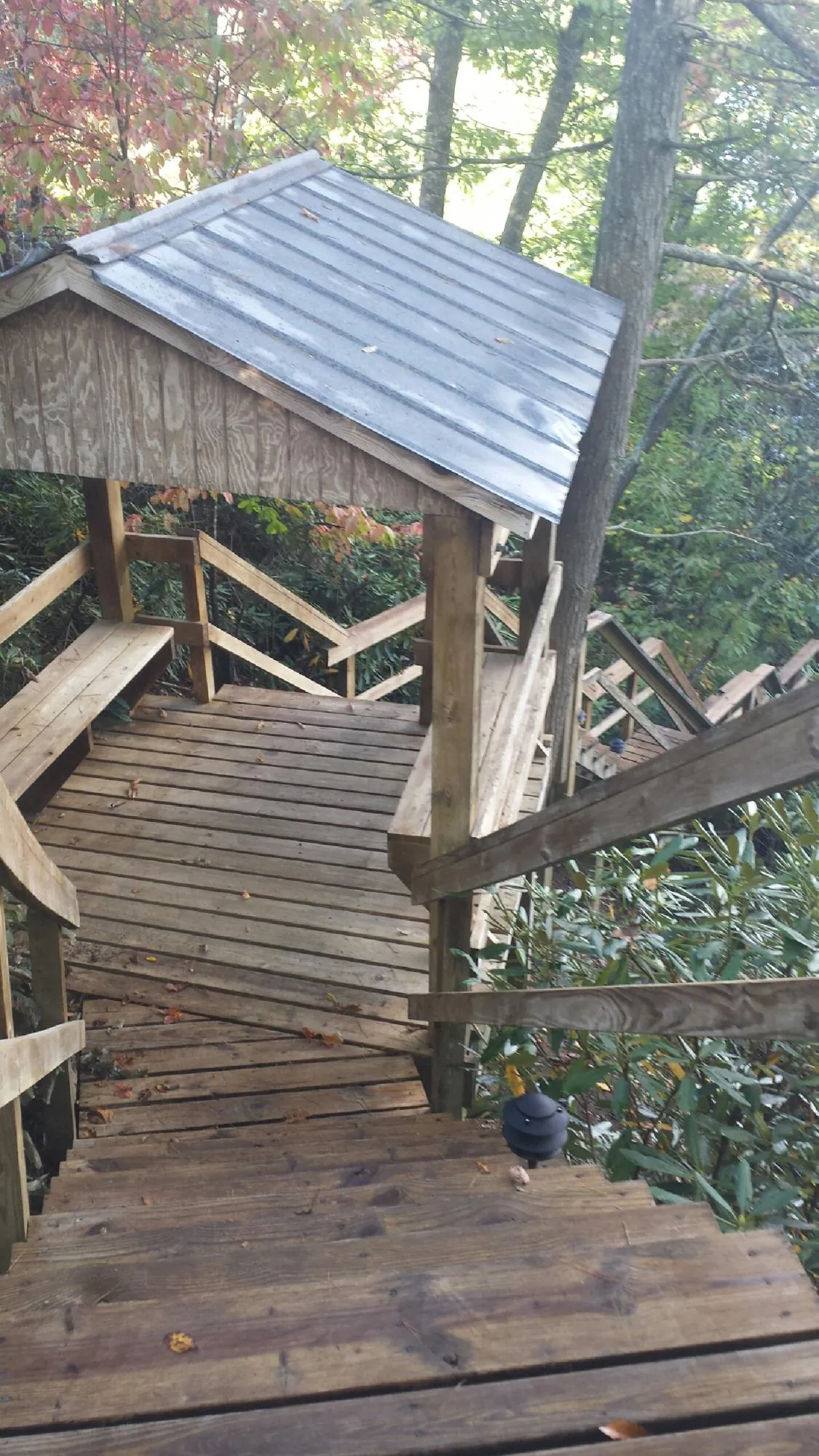 Metal roofed shelter over wooden steps on a wooded walkway — Skylight Repair & Installation work by our crew in Elbridge