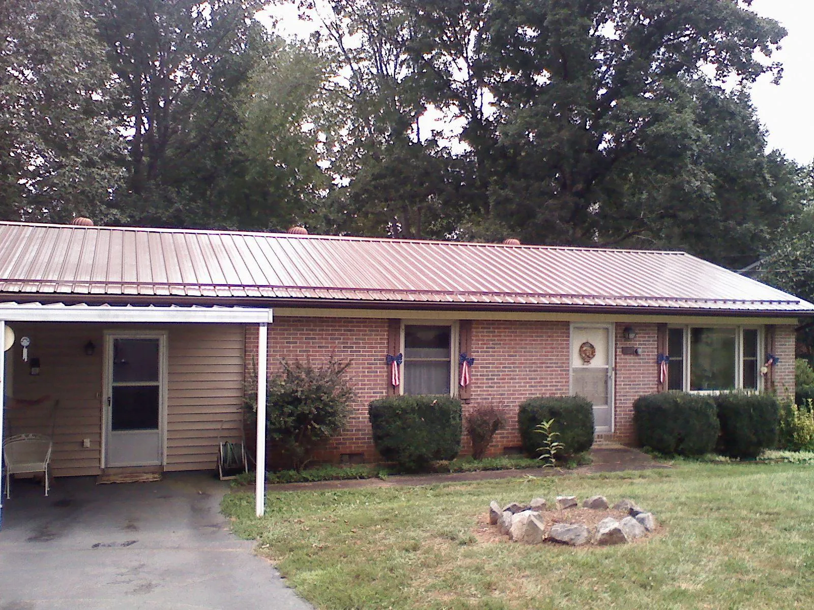 Bronze metal roof and carport on a brick ranch home — Roof Repair work by our crew in Elbridge